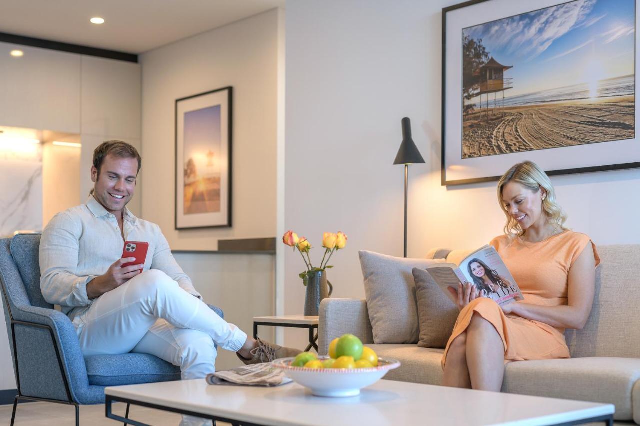 Meriton Suites Surfers Paradise Голд-Кост Екстер'єр фото A couple reading a magazine in their living room